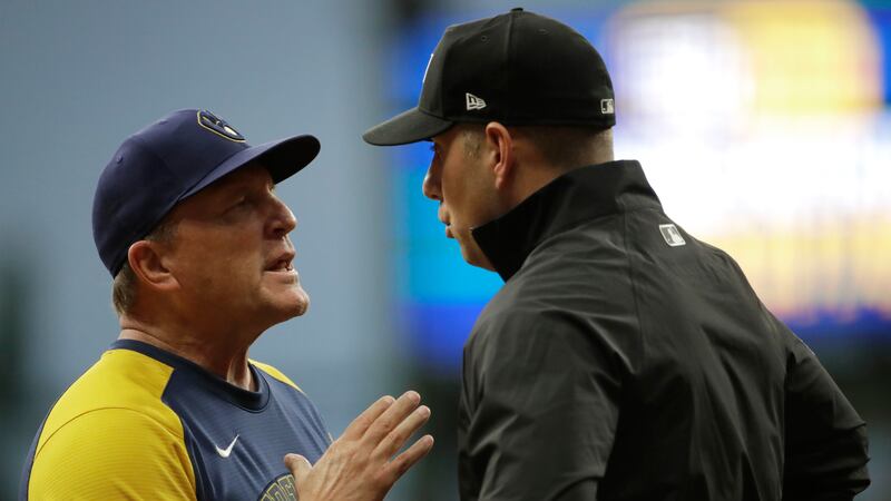 Milwaukee Brewers' bench coach Pat Murphy, left, talks with umpire John Libka during the sixth...