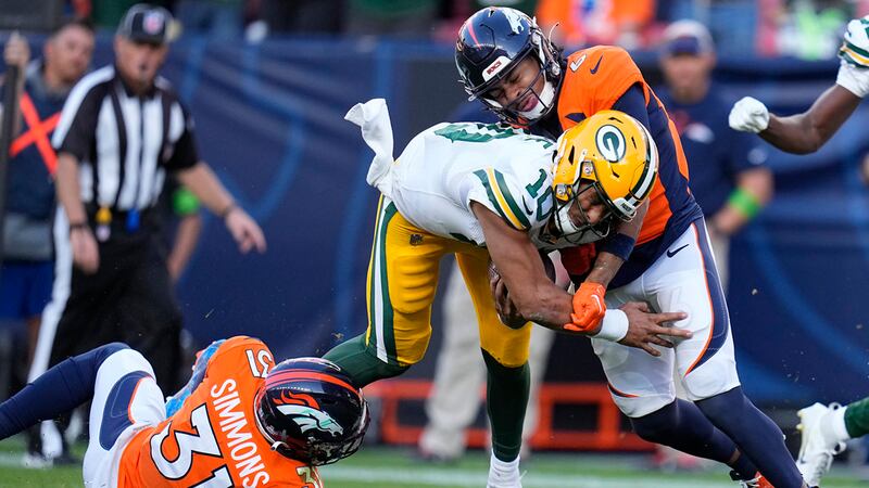 Green Bay Packers quarterback Jordan Love (10) runs against Denver Broncos safety Justin...