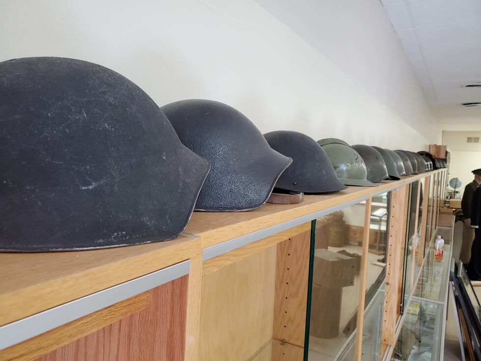 A collection of military helmets sits in Esse's downtown shop