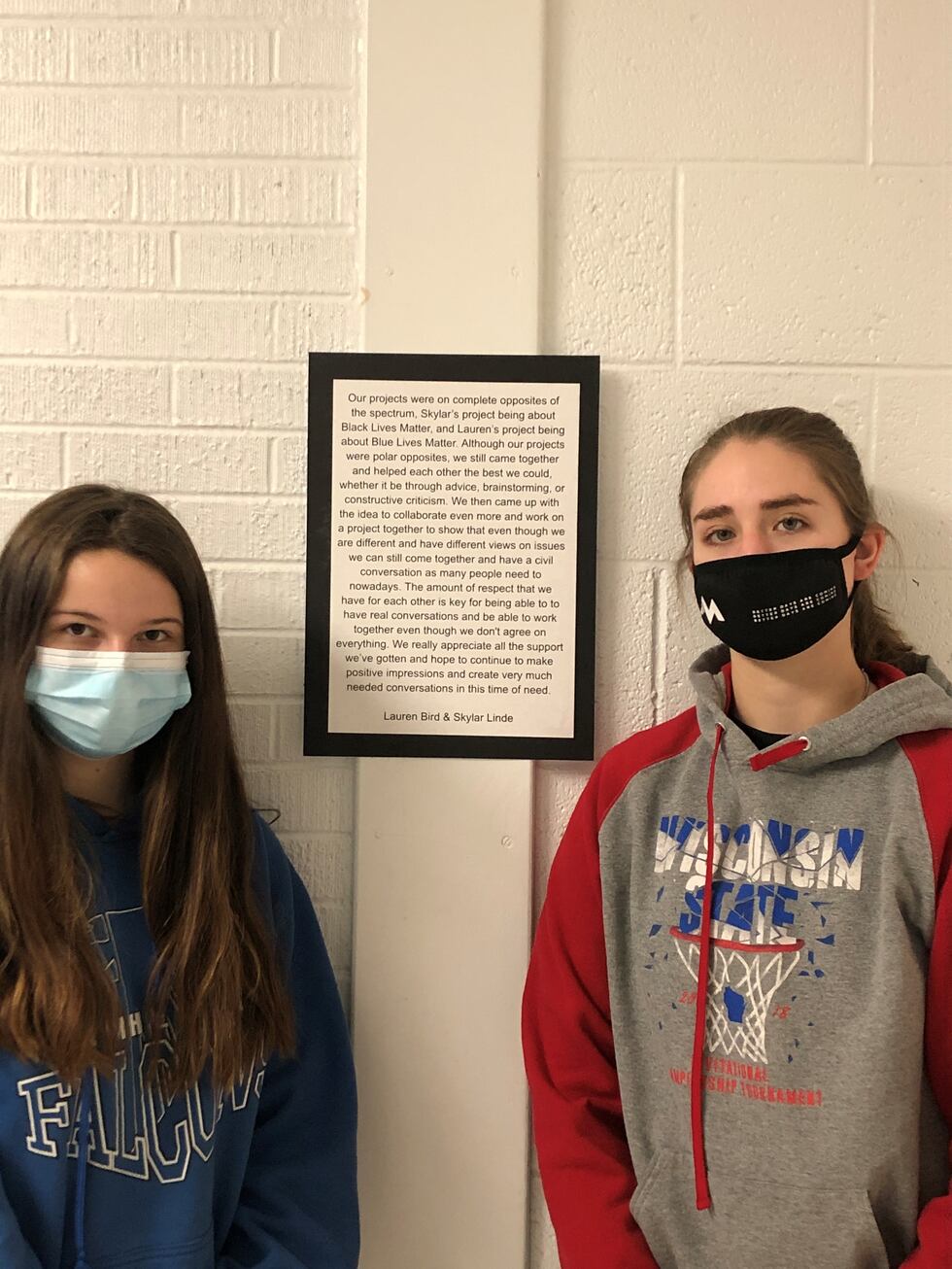 Lauren Bird (right) and Skylar Linde (left) pose in front of the explanation they wrote about...
