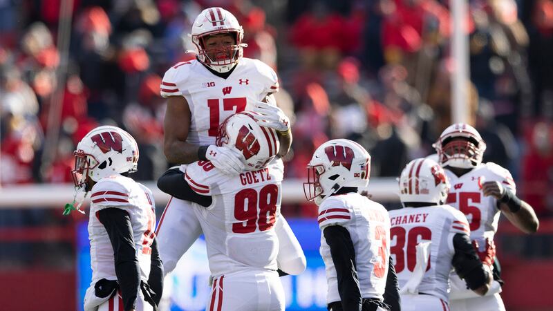 Wisconsin's Darryl Peterson (17) leaps into the arms of C.J. Goetz (98) as they celebrate...