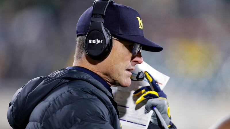Michigan coach Jim Harbaugh looks on during the second half of an NCAA college football game...