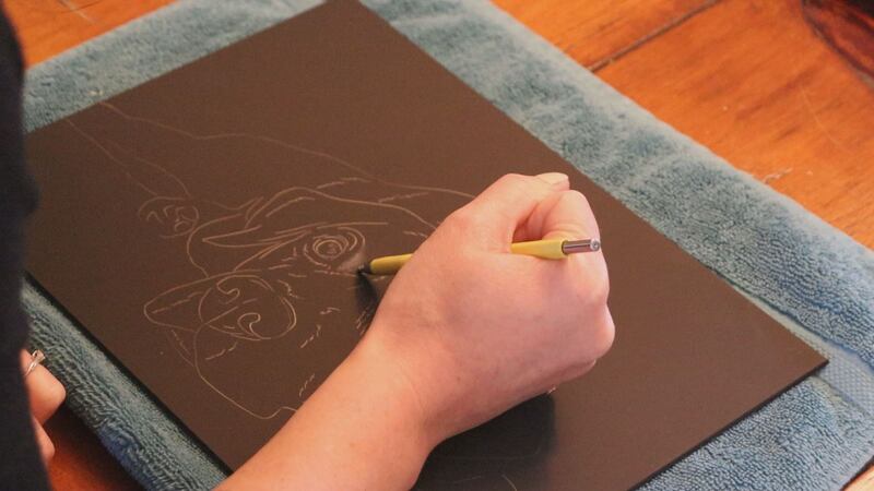 Scratchboard artist Melissa Mason works on a project while at home on quarantine on March 17,...