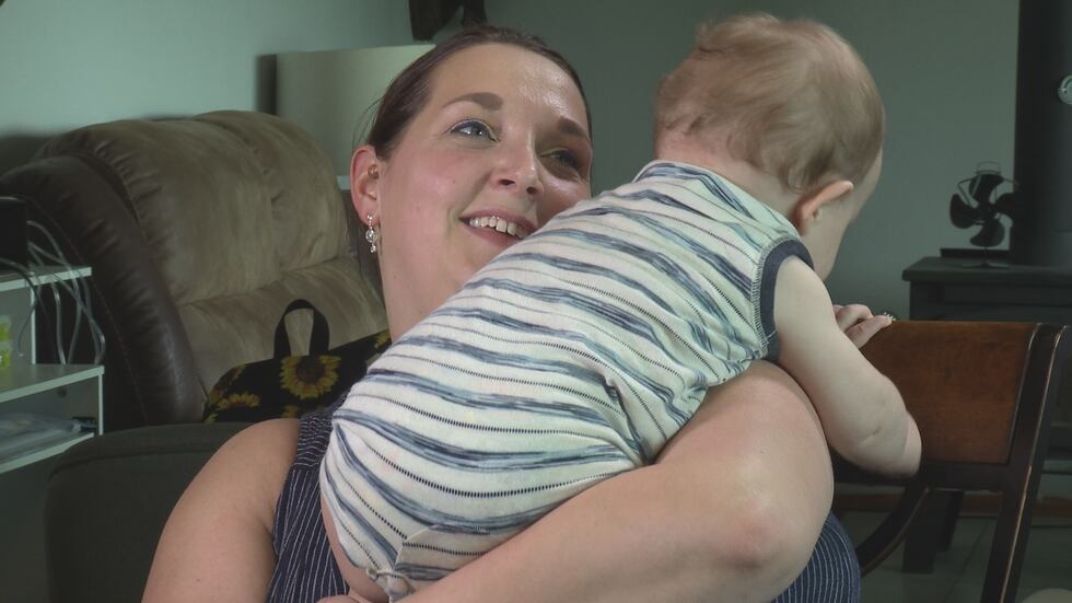 Nicki Woitula holds her son at her home in Stevens Point. Since they do not have child care...