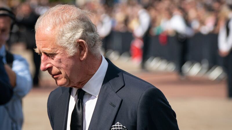Britain's King Charles III, looks at flowers outside Buckingham Palace following Thursday's...